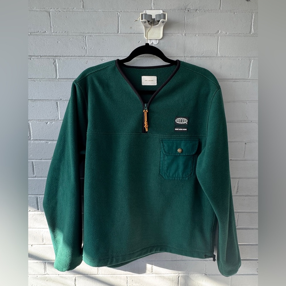 Aimee Leon Dore green fleece quarter zip sweater.